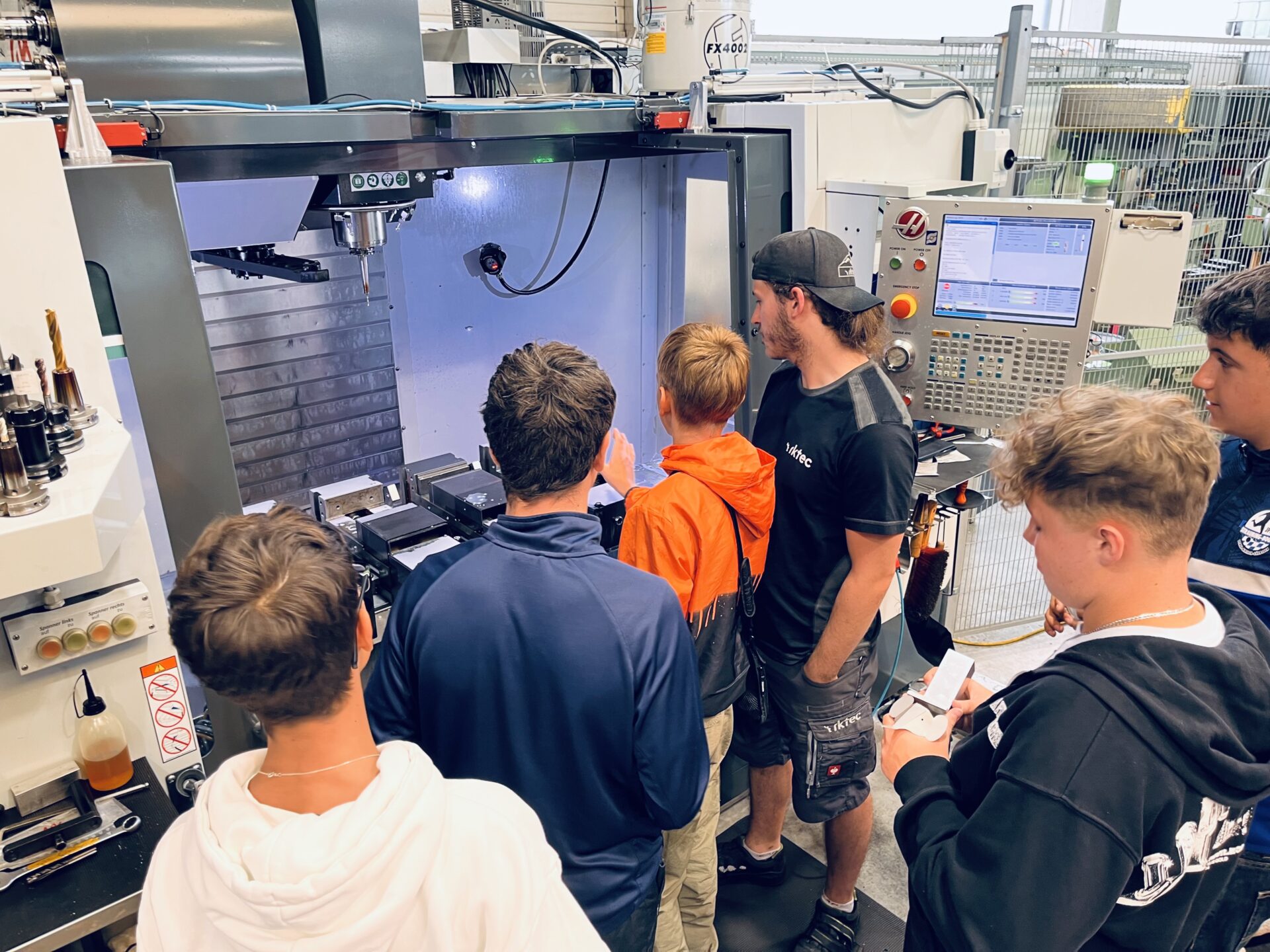 RK-tec-Mitarbeiter zeigt Schülern der Mittelschule Ittling ein CNC-Bearbeitungszentrum